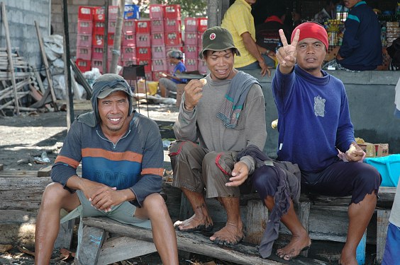 Eine Gruppe Hafenarbeiter in Kusamba wartet auf das nächste Schiff zum Abfertigen